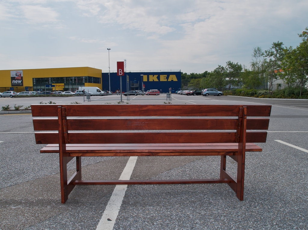 Wooden bench in car park overlooking ikea store.